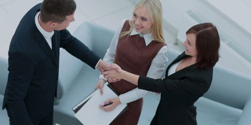 Three business people shaking hands in agreement