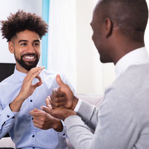 Young Black man signing ok to a another man signing help